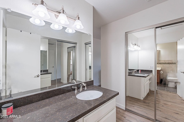 8414 N Central Ave Unit C, Phoenix, AZ 85020 - full bathroom with toilet, two vanities, and wood finished floors