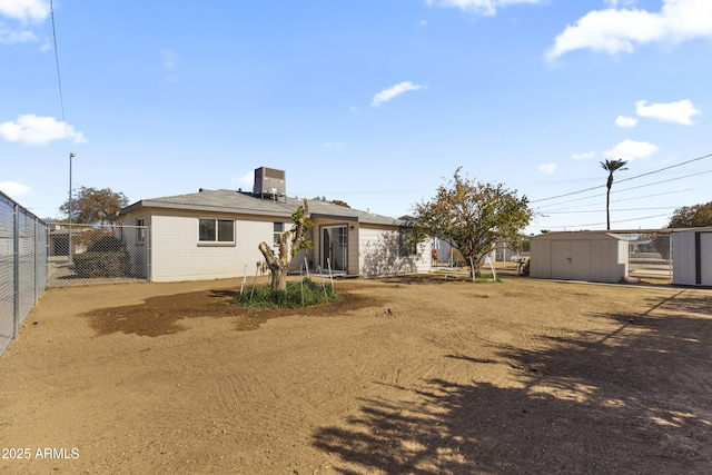 rear view of property featuring a storage shed