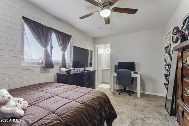 bedroom featuring connected bathroom, ceiling fan, and brick wall