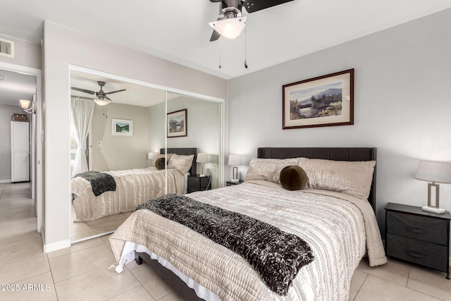 bedroom featuring light tile patterned floors, ceiling fan, and a closet