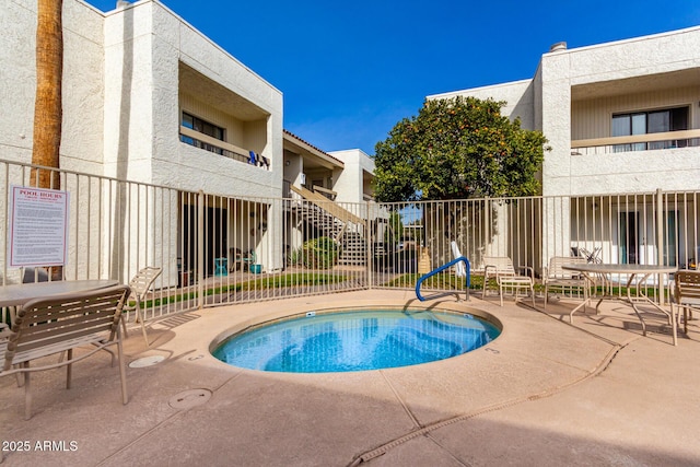 view of pool featuring a community hot tub and a patio area