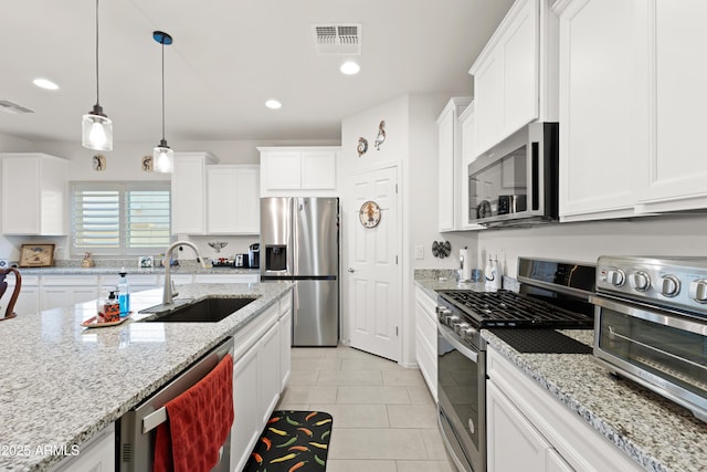 3655 N Astoria Dr, Florence, AZ 85132 - kitchen featuring stainless steel appliances, a sink, white cabinets, light tile patterned floors, and pendant lighting
