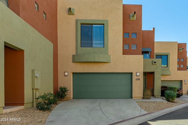 pueblo revival-style home with a garage