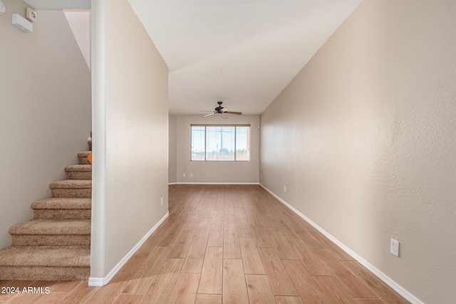 interior space with ceiling fan, lofted ceiling, and light wood-type flooring