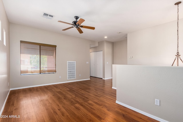 empty room with dark wood-type flooring and ceiling fan