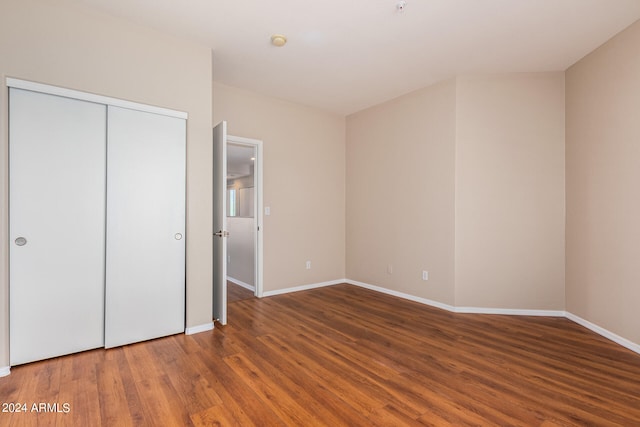 unfurnished bedroom featuring dark wood-type flooring and a closet