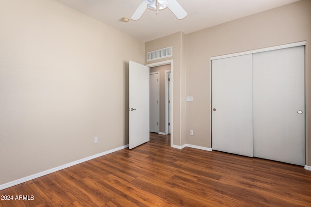 unfurnished bedroom featuring a closet, dark wood-type flooring, and ceiling fan