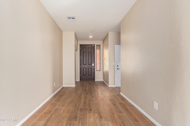 corridor with light hardwood / wood-style floors