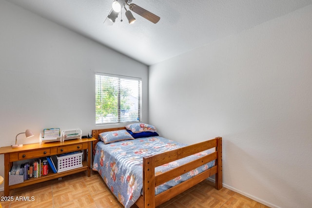 bedroom featuring light parquet flooring, lofted ceiling, a textured ceiling, and ceiling fan