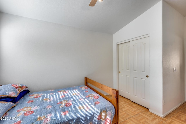 bedroom with ceiling fan, vaulted ceiling, a closet, and light parquet floors