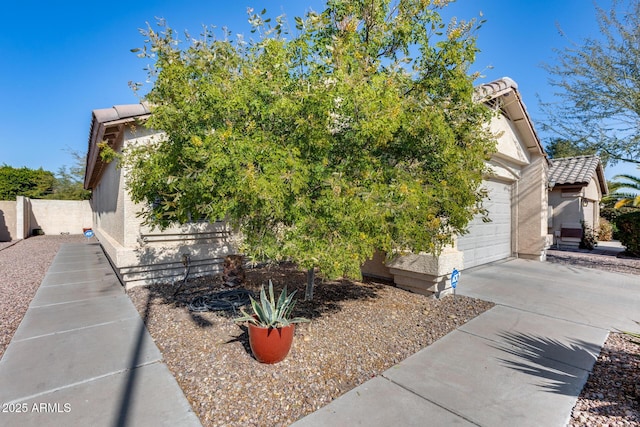 view of property hidden behind natural elements with a garage