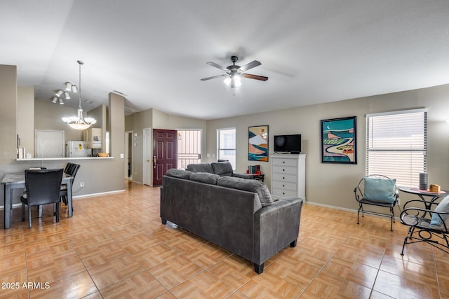 living room with light parquet flooring, lofted ceiling, and ceiling fan with notable chandelier