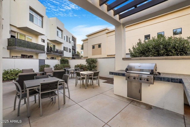 view of patio / terrace with area for grilling, a pergola, and exterior kitchen