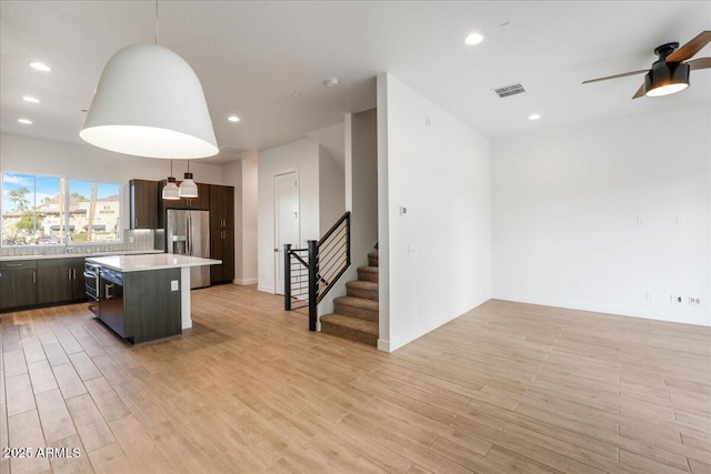 1717 E Morten Ave Unit 2, Phoenix, AZ 85020 - kitchen featuring a center island, light hardwood / wood-style flooring, decorative light fixtures, sink, and a kitchen bar