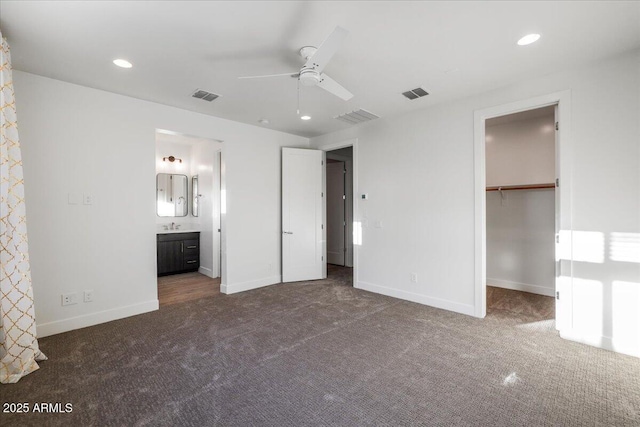 1717 E Morten Ave Unit 2, Phoenix, AZ 85020 - unfurnished bedroom featuring dark carpet, ceiling fan, a walk in closet, and connected bathroom