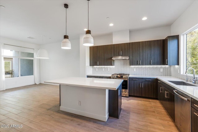 1717 E Morten Ave Unit 2, Phoenix, AZ 85020 - kitchen featuring hanging light fixtures, a center island, sink, dark brown cabinets, and appliances with stainless steel finishes