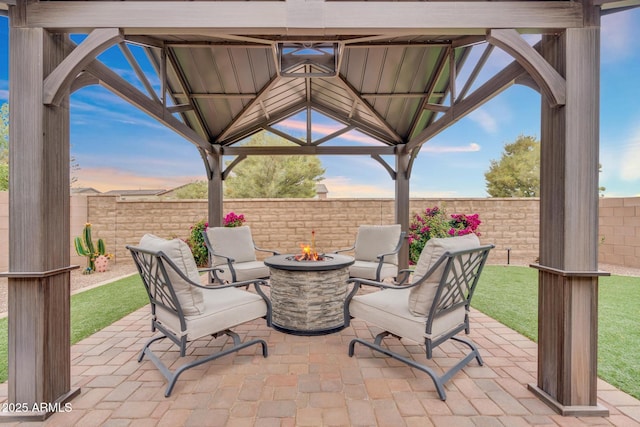 6754 E Via Rancho Rosario, Tucson, AZ 85756 - patio terrace at dusk featuring a gazebo, an outdoor fire pit, and a fenced backyard