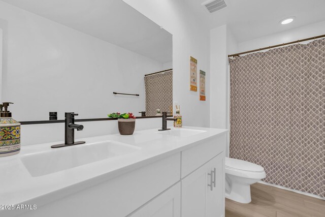 6754 E Via Rancho Rosario, Tucson, AZ 85756 - bathroom with toilet, wood finished floors, double vanity, and a shower with shower curtain