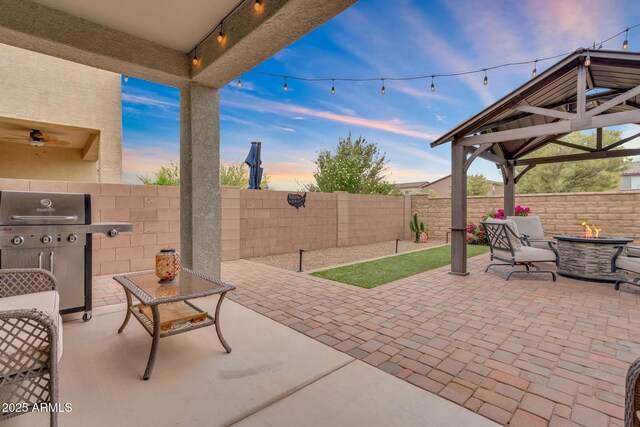 6754 E Via Rancho Rosario, Tucson, AZ 85756 - patio terrace at dusk featuring an outdoor fire pit, a gazebo, a fenced backyard, and a grill