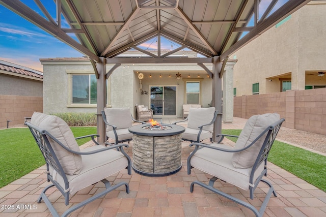 6754 E Via Rancho Rosario, Tucson, AZ 85756 - patio terrace at dusk featuring an outdoor fire pit, a fenced backyard, and a gazebo