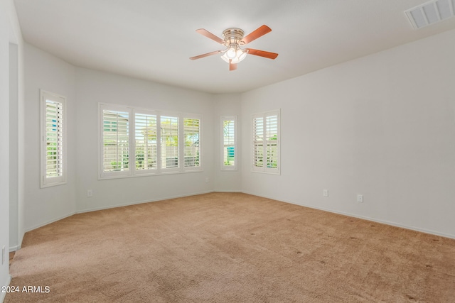 carpeted spare room with ceiling fan