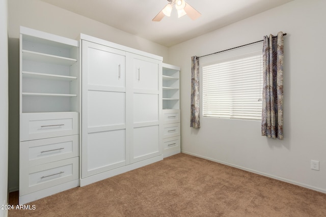 unfurnished bedroom with ceiling fan, light colored carpet, and a closet