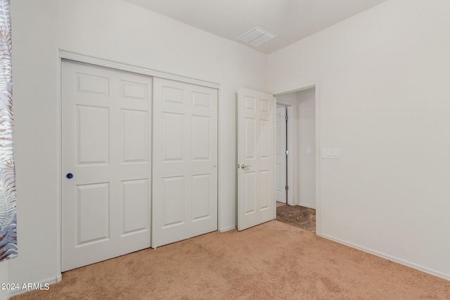 unfurnished bedroom featuring a closet and light carpet