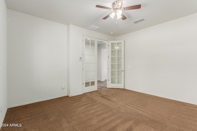 carpeted spare room featuring french doors and ceiling fan