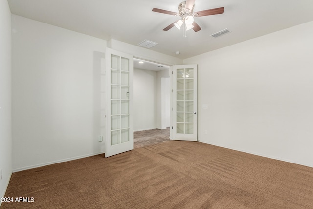 empty room featuring ceiling fan, french doors, and carpet floors