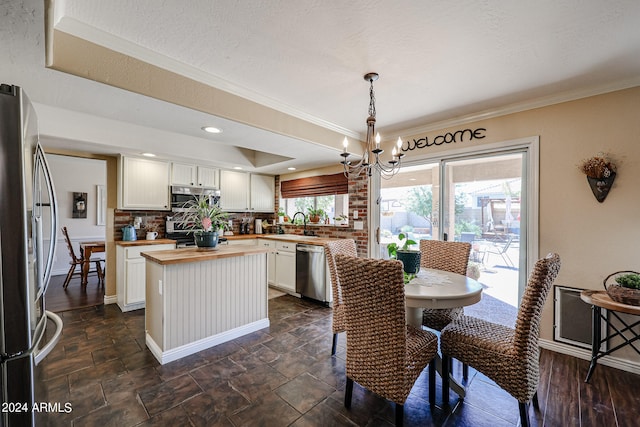 dining area with plenty of natural light, a chandelier, and crown molding