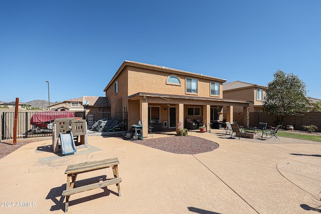 rear view of property with an outdoor fire pit and a patio area