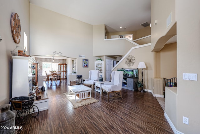 living room featuring dark wood-type flooring and a towering ceiling