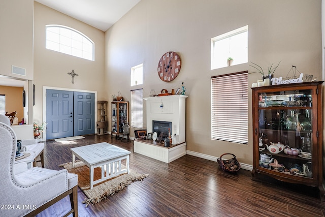 living room with dark wood-type flooring, high vaulted ceiling, and a healthy amount of sunlight