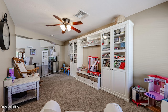 playroom with ceiling fan and dark carpet