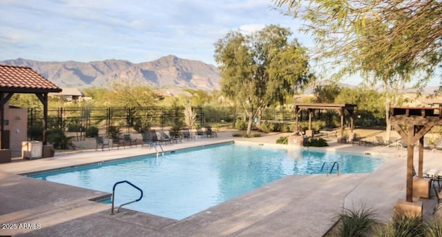 view of swimming pool with a mountain view and a patio area