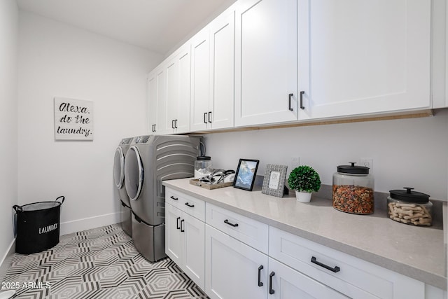 laundry area featuring cabinets, light tile patterned floors, and washing machine and dryer