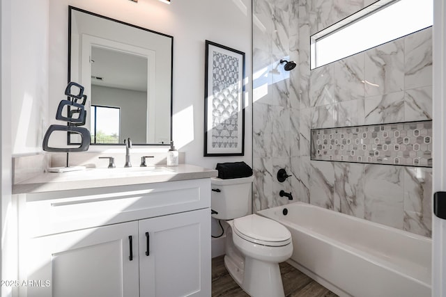 full bathroom with hardwood / wood-style floors, toilet, vanity, and tiled shower / bath