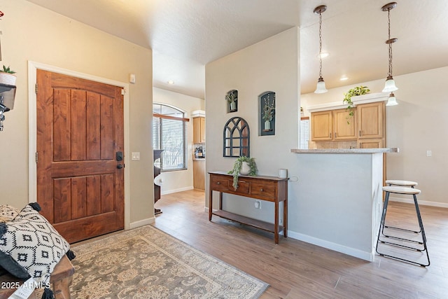 foyer with baseboards and light wood finished floors