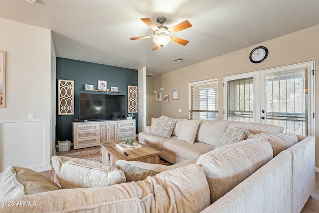 living area featuring visible vents, a ceiling fan, and french doors