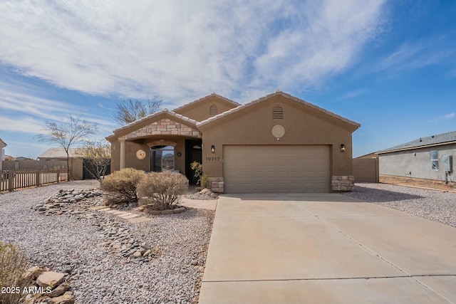 view of front facade with fence, stucco siding, driveway, stone siding, and an attached garage