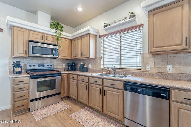 kitchen featuring light brown cabinets, appliances with stainless steel finishes, and a sink