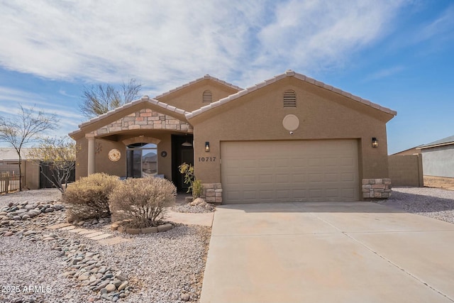 view of front of property featuring a garage, stone siding, concrete driveway, and fence