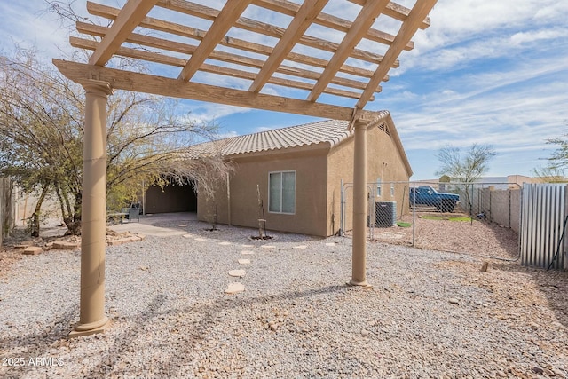 exterior space featuring fence, central air condition unit, a tile roof, stucco siding, and a pergola