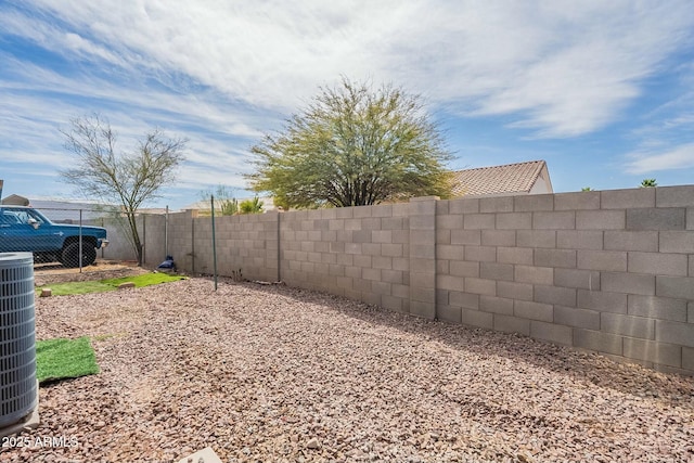 view of yard with central AC and a fenced backyard