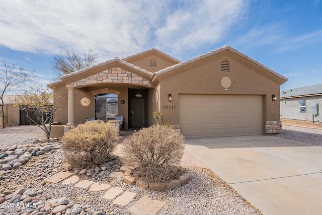 view of front facade featuring an attached garage, driveway, and stucco siding