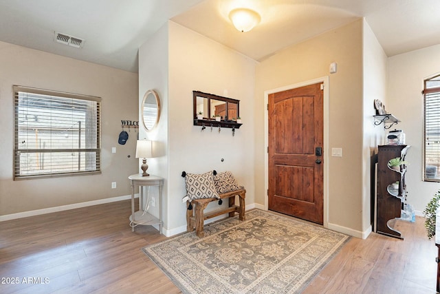 entryway featuring visible vents, baseboards, and light wood finished floors