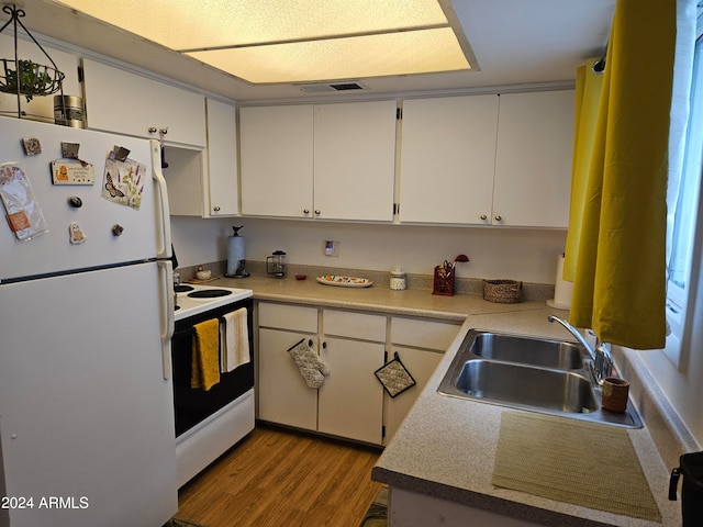 kitchen with white appliances, white cabinetry, light hardwood / wood-style floors, and sink