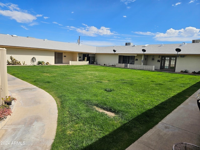 ranch-style home featuring a front lawn and french doors