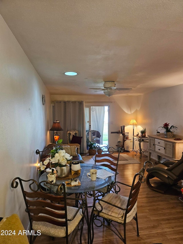 dining room with a textured ceiling, dark hardwood / wood-style floors, and ceiling fan