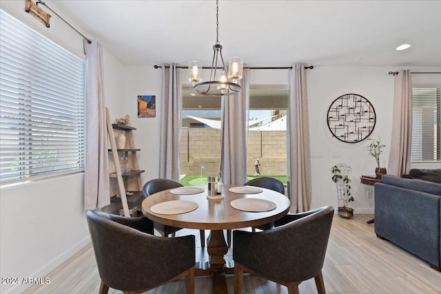 dining room featuring light wood-type flooring and an inviting chandelier